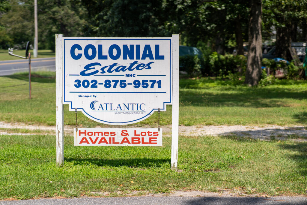 a real estate sign in front of a home and lot