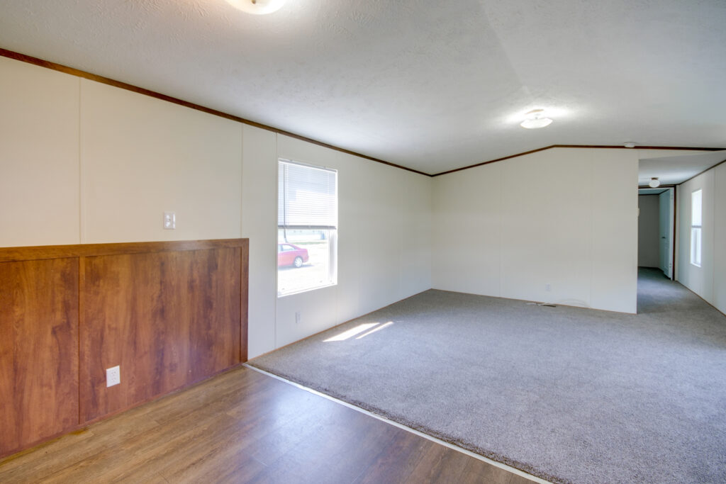 an empty room with wood floors and white walls
